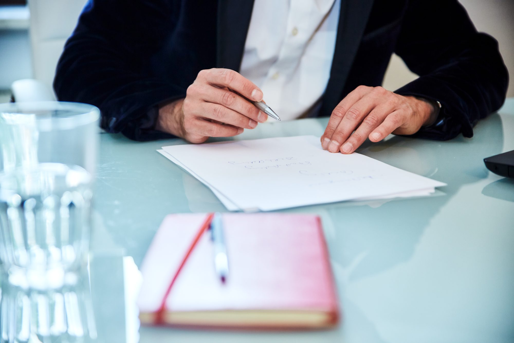 Executive Sparring und Coaching: Hände mit Stift über handschriftlichen Notizen
